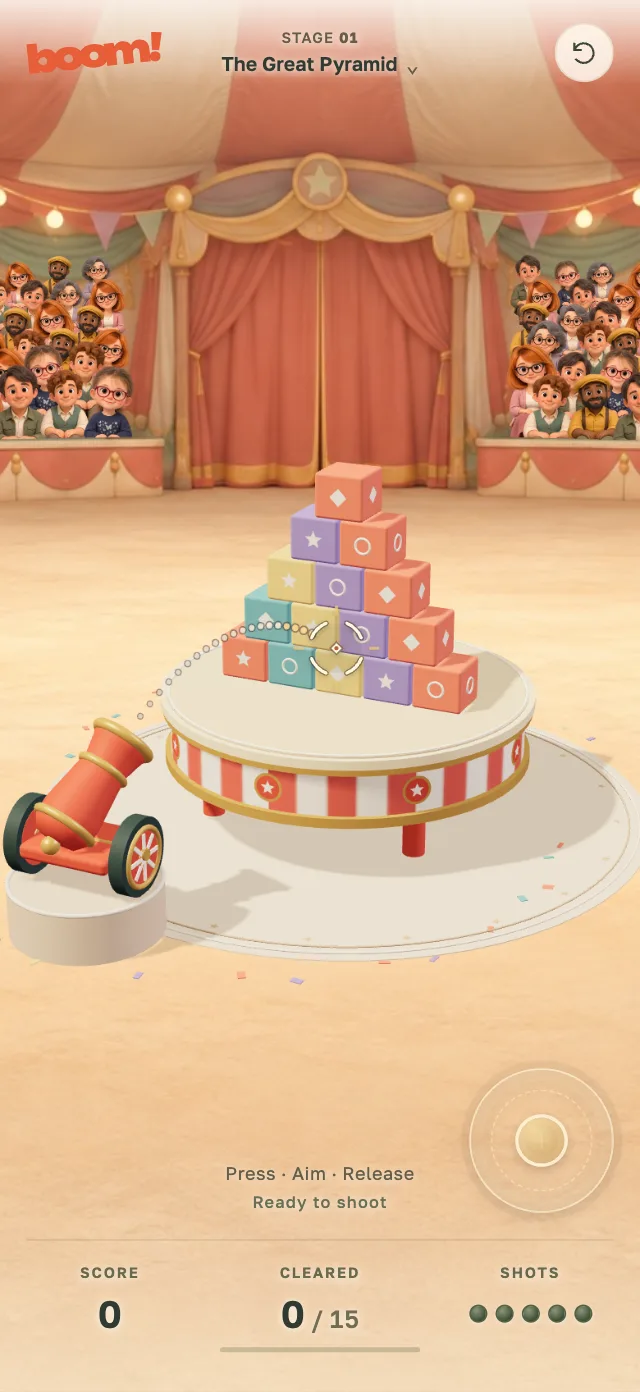 BOOM! on a phone: a circus cannon aimed at a pyramid of colorful props on a striped table, with a cheering crowd behind